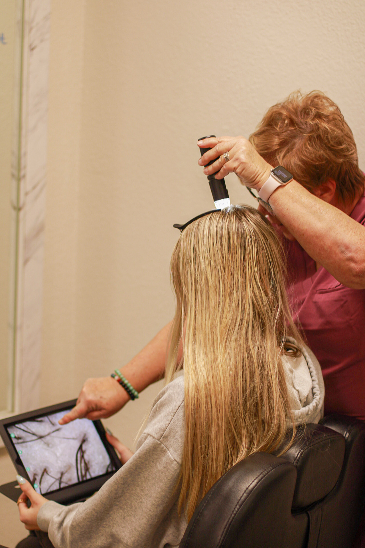 Kerri performing a scalp analysis with a digital microscope during a trichology consultation